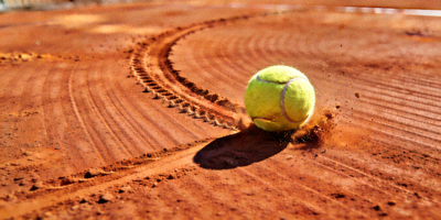 网球红土场地特写，球在场地上的痕迹清晰可见